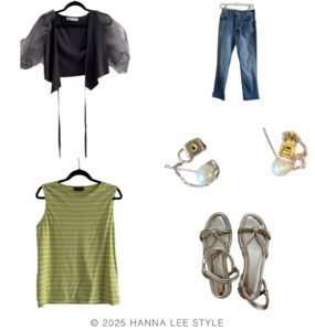 travel capsule wardrobe outfit example with grey bolero style top with puff sleeve, yellow stripe sleeveless top, pair of denim, small pearl earrings with chain and metallic sandal